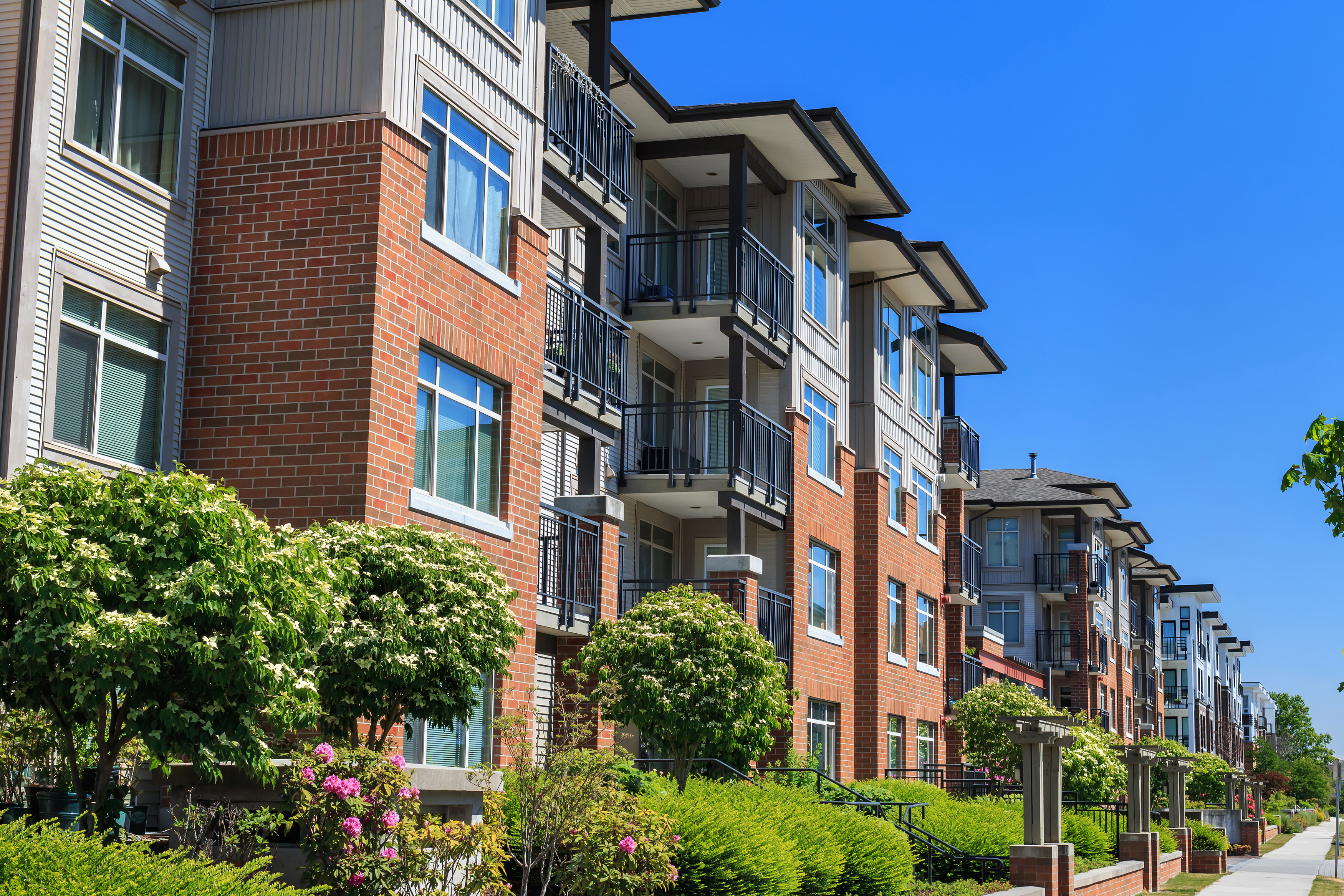 Exterior shot of a block of condos on a sunny day.