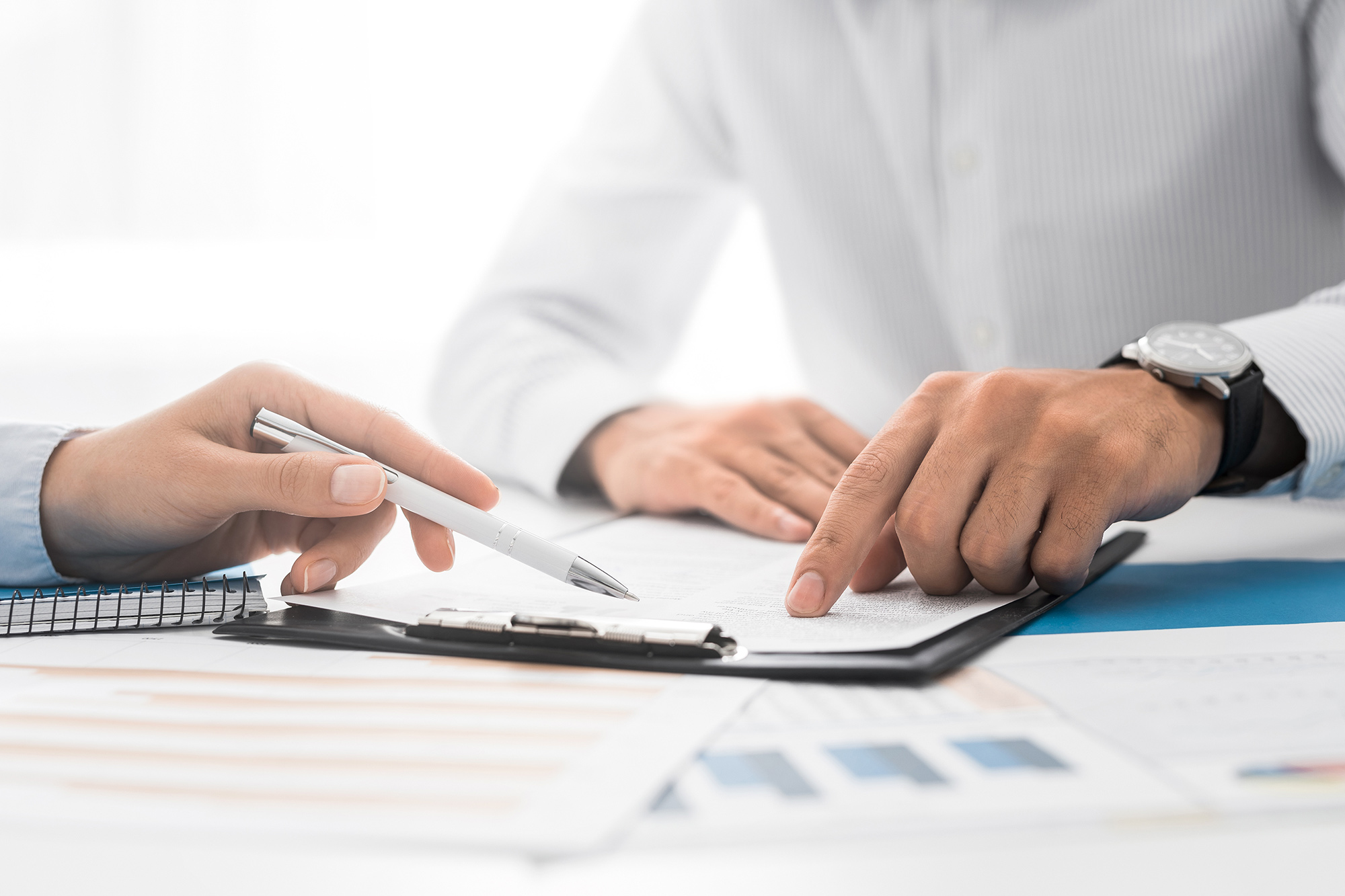 Close-up of two business people reviewing notes.