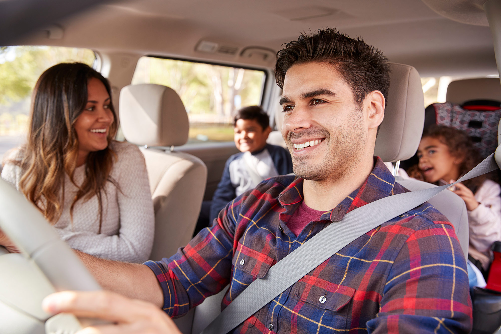 Happy family of four in a vehicle.