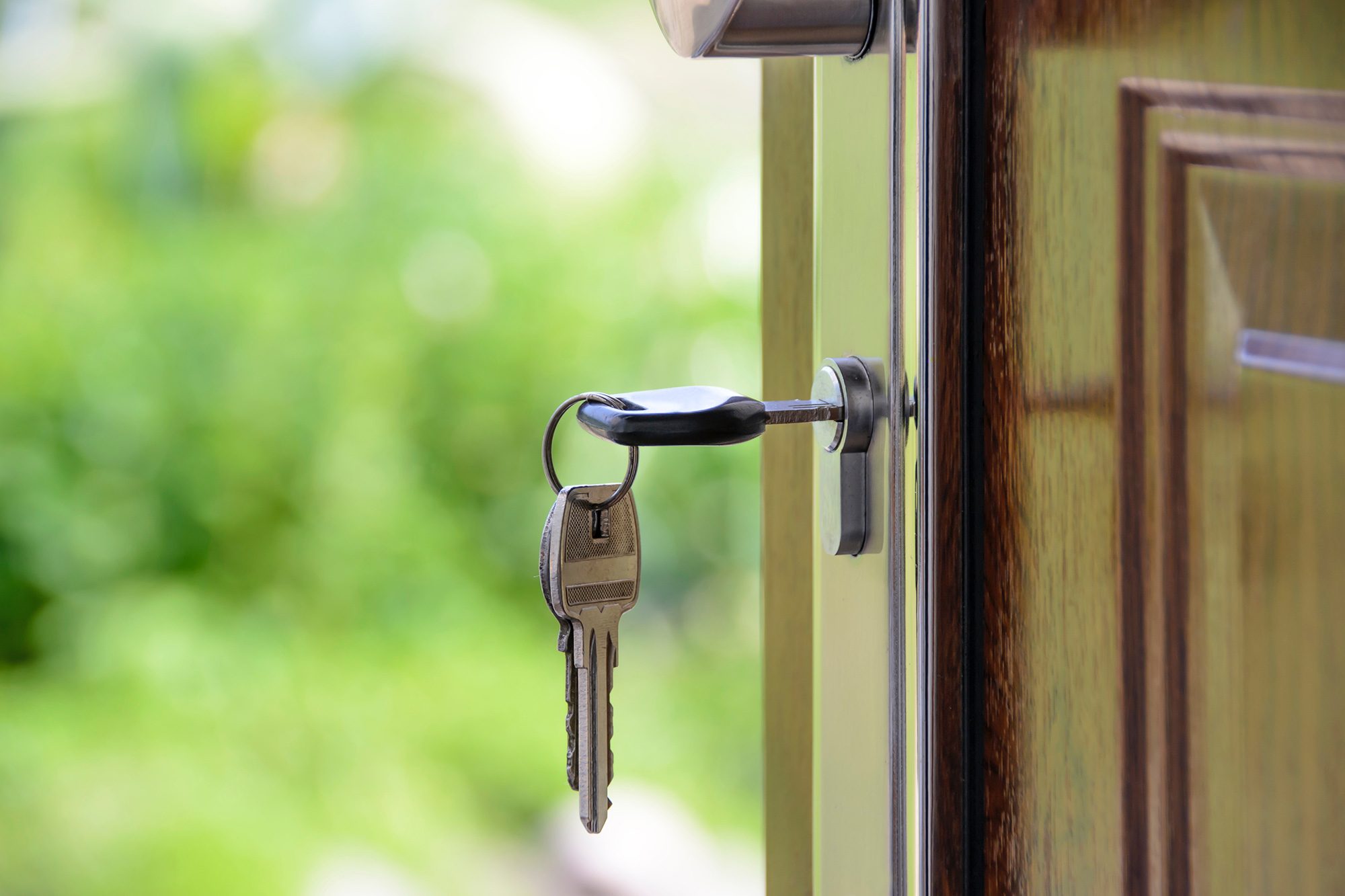 Close-up of house key inserted into lock of home's front door.