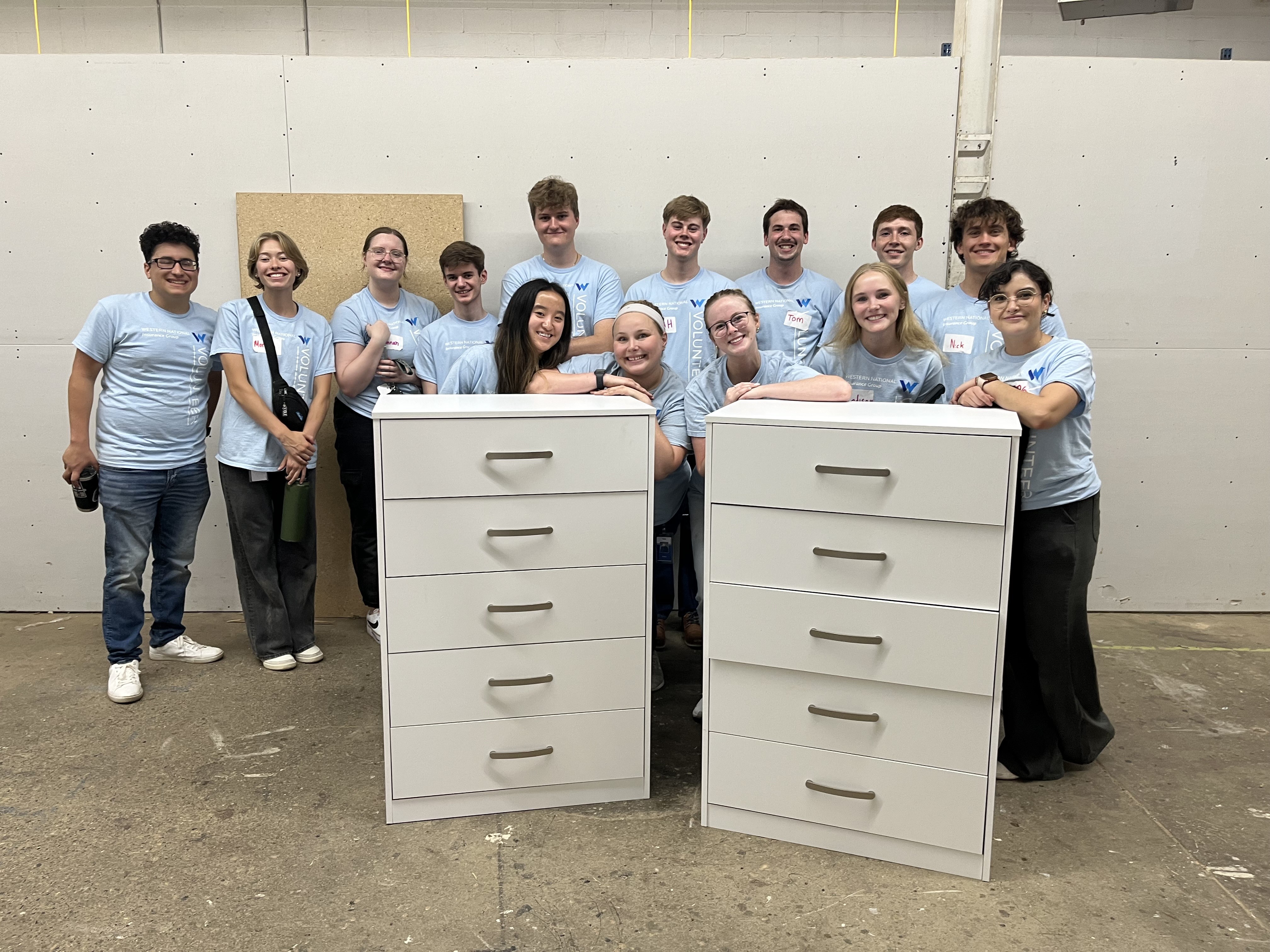 A group of interns standing behind a white dresser